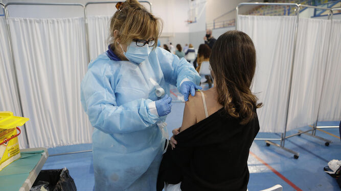 Vacunación de una docente no universitaria en las instalaciones deportivas de la US en Los Bermejales.