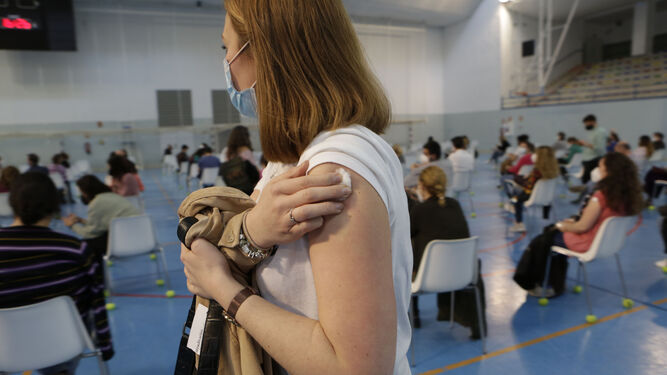 Una profesora en Sevilla tras ser vacunada en el pabellón deportivo de Los Bermejales.